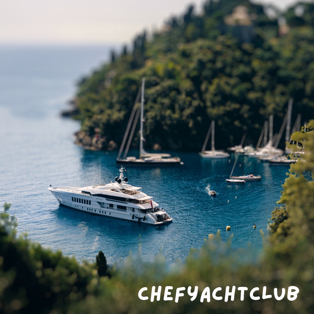 A superyacht at anchor in a Mediterranean cove